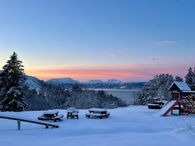 a snow covered area with picnic tables in the snow at Vintage apartment with fresh sea air and pets in Kristiansund