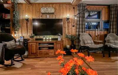 a living room with a flat screen tv on a wooden wall at 3 Bedroom Amazing Home In Tysse in Tysse