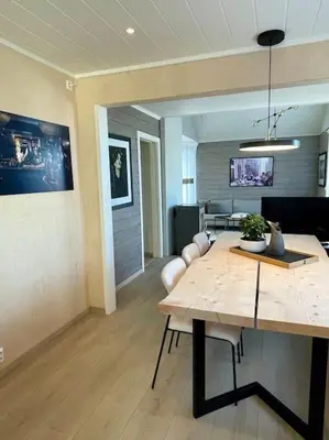 a dining room with a table and a living room at Et helt hus i fredelige omgivelser med utsikt! ca 10 min fra Trondheim sentrum in Trondheim