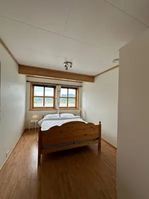 a bedroom with a bed in a room with a window at Hus med panorama utsikt in Måløy