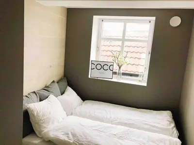 a bed sitting under a window with a sign on it at Very Central Beautiful Modern Apartment in Bergen