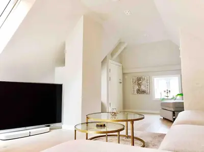 a living room with a large television and a table at Very Central Beautiful Modern Apartment in Bergen