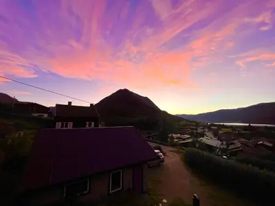 a view of a house with a mountain in the background at Hyggelig og velutstyrt leilighet i Lom sentrum in Lom