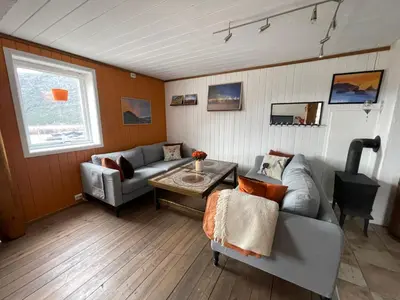 a living room with a couch and a table at Hyggelig og velutstyrt leilighet i Lom sentrum in Lom