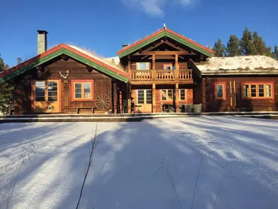 a large wooden house with snow in front of it at Rondane - Øvre Nordli Sollia Friluftsliv in Atnfoss