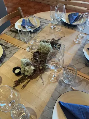 a wooden table with wine glasses and flowers on it at Rondane - Øvre Nordli Sollia Friluftsliv in Atnfoss