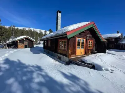 a log cabin with a snow covered roof at Rondane - Øvre Nordli Sollia Friluftsliv in Atnfoss