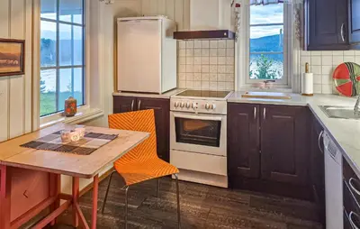 a kitchen with a table and a stove top oven at 2 Bedroom Nice Home In Skatval in Tilleraune