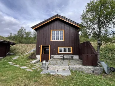 a brown house with a bench in front of it at Perfect Couple's Hideaway In Nature! in Beitostøl