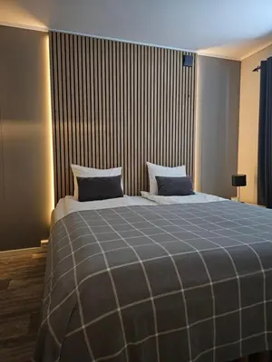 a bedroom with a large bed with a blue blanket at Leilighet Vingnes in Lillehammer