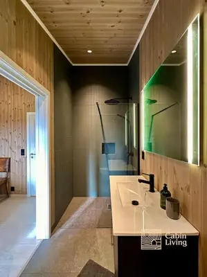 a bathroom with a sink and a shower with a mirror at New large cabin with sauna in Hafjell in Nordseter