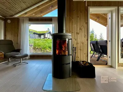 a fireplace in the middle of a living room at New large cabin with sauna in Hafjell in Nordseter