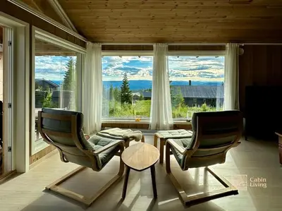 two chairs and a table in front of a window at New large cabin with sauna in Hafjell in Nordseter