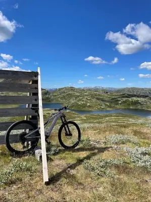 a bike parked next to a fence in a field at Eksklusiv hytte ved Fyri Resort - Utsikt in Hemsedal