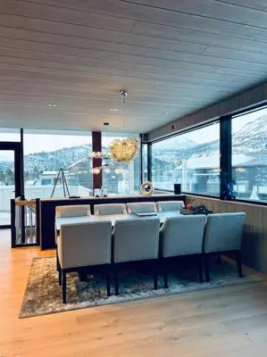 a dining room with a table and chairs and mountains at Eksklusiv hytte ved Fyri Resort - Utsikt in Hemsedal