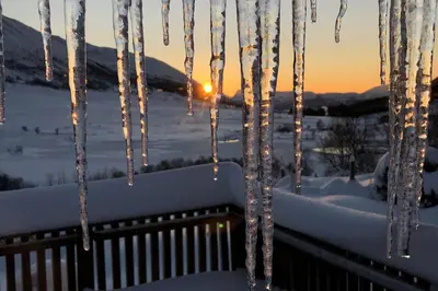 a group of icicles hanging from a railing in the snow at Peaceful cabin retreat in the Norwegian mountains in Ulsteinvik