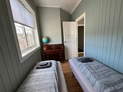 a bedroom with two beds and a window at Sentral leilighet i klassisk hus! in Lillehammer