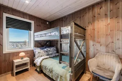 a bedroom with two bunk beds and a chair at Leilighet på Bualie, Golsfjellet in Gol