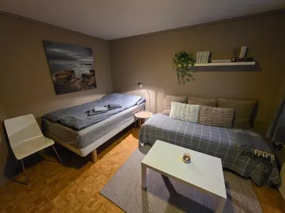 a small bedroom with a bed and a table at Rom 6 sentralt i Sogndal in Sogndal