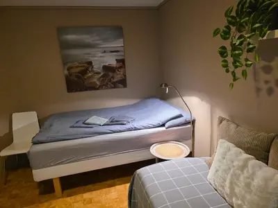 a small bedroom with a bed and a couch at Rom 6 sentralt i Sogndal in Sogndal