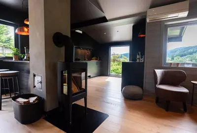 a living room with a fireplace and a chair at Lite hus 40 minutter unna Bergen in Bjørkheim