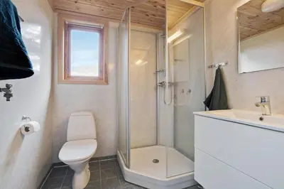 a bathroom with a shower and a toilet and a sink at Gunnarhytta, Valevåg in Valevåg