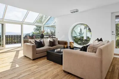 a living room with two couches and a table at 7 min to Ski Championship, Glass front house, Terrace in Trondheim