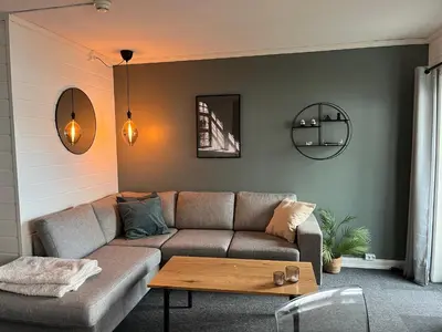 a living room with a couch and a table at Flott Leilighet i stølen oppdal for 6 personer, ski in, ski out in Oppdal