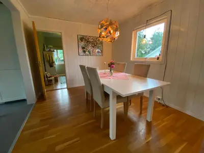 a dining room with a white table and chairs at Villekulla - Koselig hus med jazzuci i Hamar in Hamar