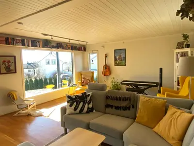 a living room with a couch and a table at Villekulla - Koselig hus med jazzuci i Hamar in Hamar