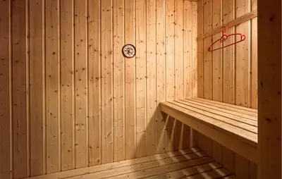 a wooden sauna with a clock on the wall at Nice Home In Lillehammer With Sauna in Lillehammer