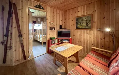 a wooden room with a table and a tv in it at Nice Home In Lillehammer With Sauna in Lillehammer