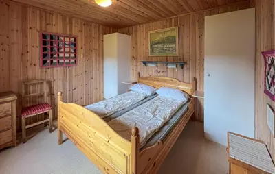 a bedroom with a wooden bed in a cabin at Nice Home In Lillehammer With Sauna in Lillehammer
