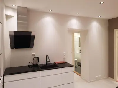 a kitchen with a sink and a tv on the wall at Moderne leilighet nær sentrum in Ålesund