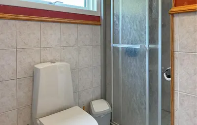 a bathroom with a toilet and a shower at 3 Bedroom Nice Home In Florø in Florø