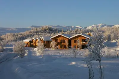 a lodge in the snow with snow covered trees and mountains at Charming 3-Bedroom Apartment With Great Views! in Beitostøl
