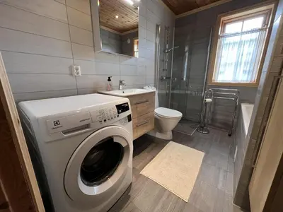 a bathroom with a washing machine and a sink at Charming 3-Bedroom Apartment With Great Views! in Beitostøl