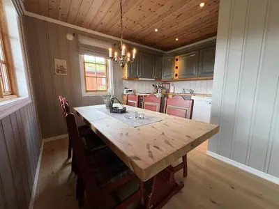 a kitchen with a large wooden table and chairs at Charming 3-Bedroom Apartment With Great Views! in Beitostøl