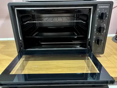 a black toaster oven with its door open at Cozy Apartment in Ålesund