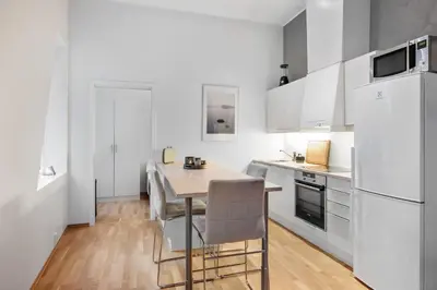 a kitchen with white appliances and a table and chairs at Modern Apartment with Rooftop Terrace and Stunning Views in Bergen