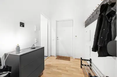 a white room with a black dresser and a closet at Modern Apartment with Rooftop Terrace and Stunning Views in Bergen