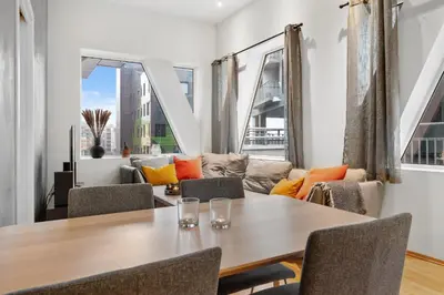 a dining room with a table and chairs and a couch at Modern Apartment with Rooftop Terrace and Stunning Views in Bergen