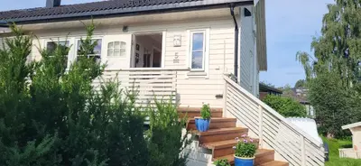 a small white house with stairs and potted plants at Dalgårdveien 5 in Trondheim