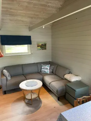 a living room with a couch and a table at Hytte ved sjøen med båtutleige in Kvalsvik