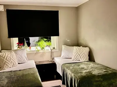 a room with two beds and a window with a television at Alesund bedroom with shared shower in Ålesund