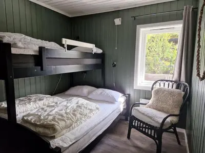 a bedroom with two bunk beds and a chair at Gaustablikk, 3 soverom, fri utsikt til fjell og innsjø in Gaustablikk