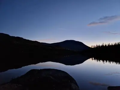 a reflection of a mountain in a lake at dusk at Gaustablikk, 3 soverom, fri utsikt til fjell og innsjø in Gaustablikk