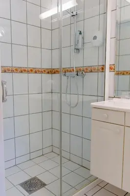 a shower with a glass door in a bathroom at Orkla Gjestebolig in Løkken