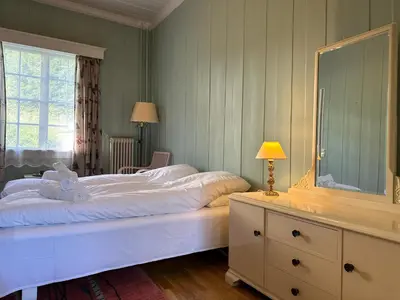 a bedroom with a large bed and a dresser with a mirror at Orkla Gjestebolig in Løkken