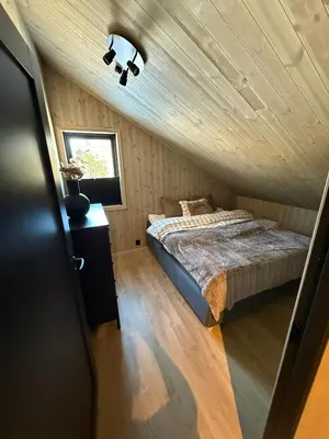 a bedroom with a bed and a wooden ceiling at Ny hytte i vakre Oppdal, Norge in Fagerhaug
